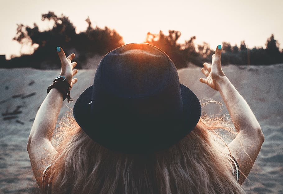 woman wearing a hat sitting on sand during dusk, sun, red sun HD wallpaper