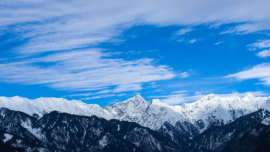 snow covered mountain under cloudy sky at daytime, aerial photo of snow covered mountain during daytime HD wallpaper