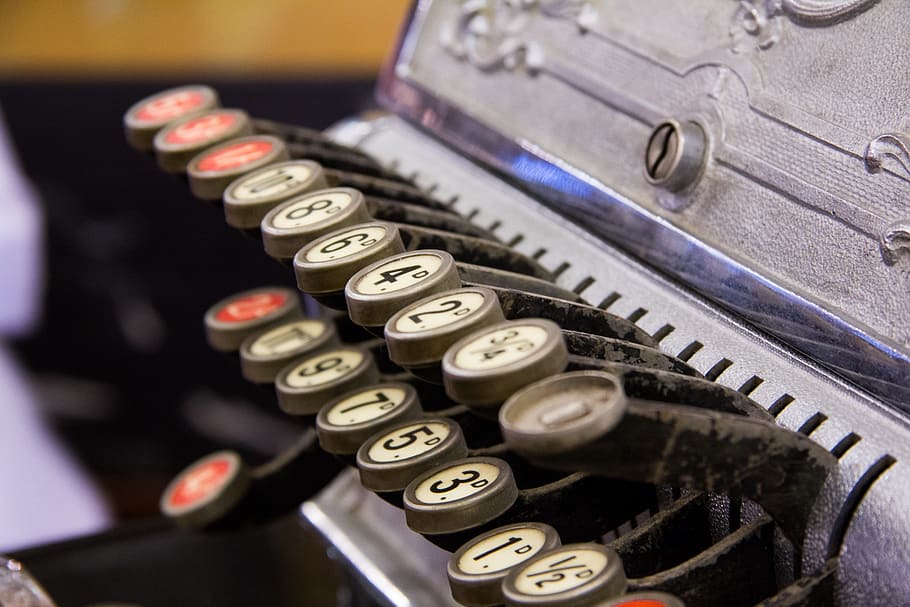 close photo of gray brail typewriter, cash register, keys, numbers