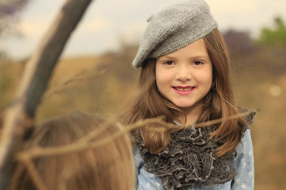 selective focus photography of smiling girl wearing gray and blue long-sleeved dress HD wallpaper