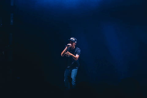 man singing inside dim room, man wearing cap singing white using microphne HD wallpaper