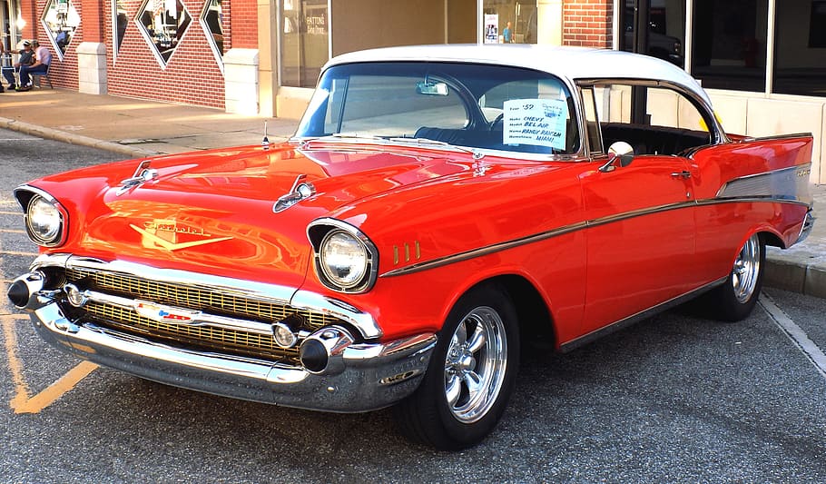 close-up photography of red Chevrolet Bel Air coupe on concrete road at daytime