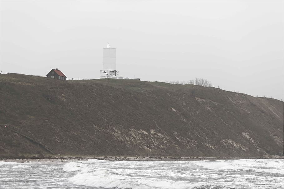 hill, coast, water, waves, grey, sea, tower, built structure HD wallpaper