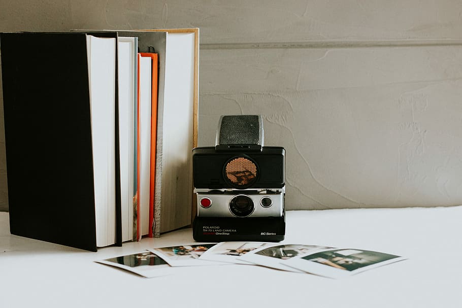 black and gray DSLR camera, four assorted-title books near camera and pictures HD wallpaper