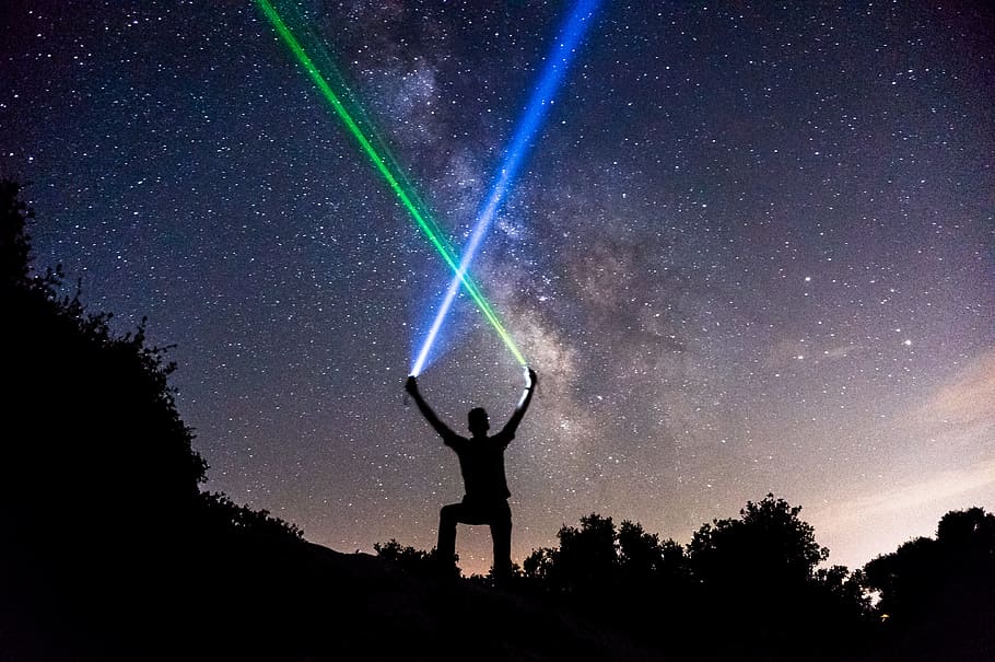 man holding green and blue flashlights, silhouette of person holding up two hands HD wallpaper