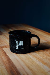 black Never Settle ceramic mug on brown wooden table, quote HD wallpaper