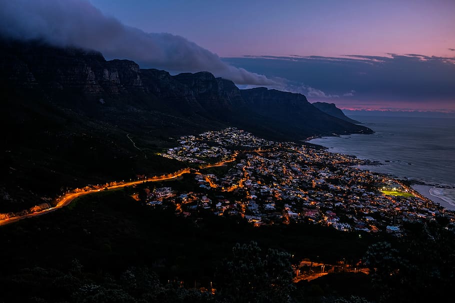 high-angle photography of city near smoky mountain and body of water during sunset, aerial photography of town during daytime HD wallpaper
