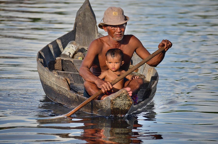 man paddling boat behind child, Cambodia, Travel, Tonle Sap, Cruise