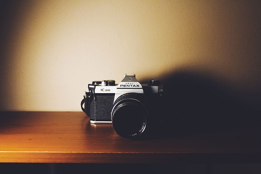 black and gray Pentax digital camera on wooden surface, black Pentax DSLR camera on brown wooden shelf HD wallpaper