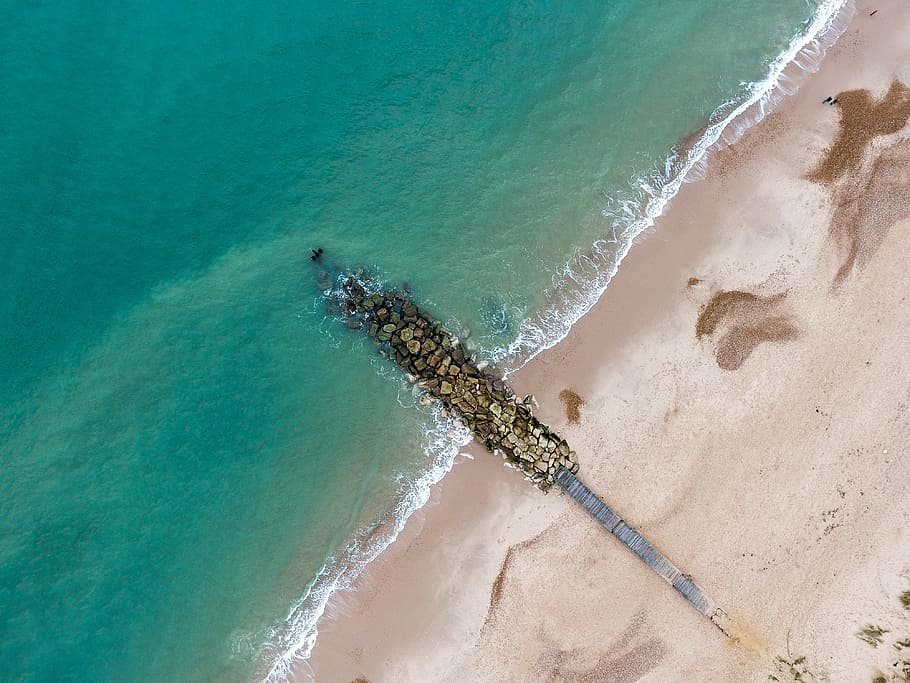 aerial view photography of stones on shore during daytime, aerial view of waves crashing on rocks HD wallpaper