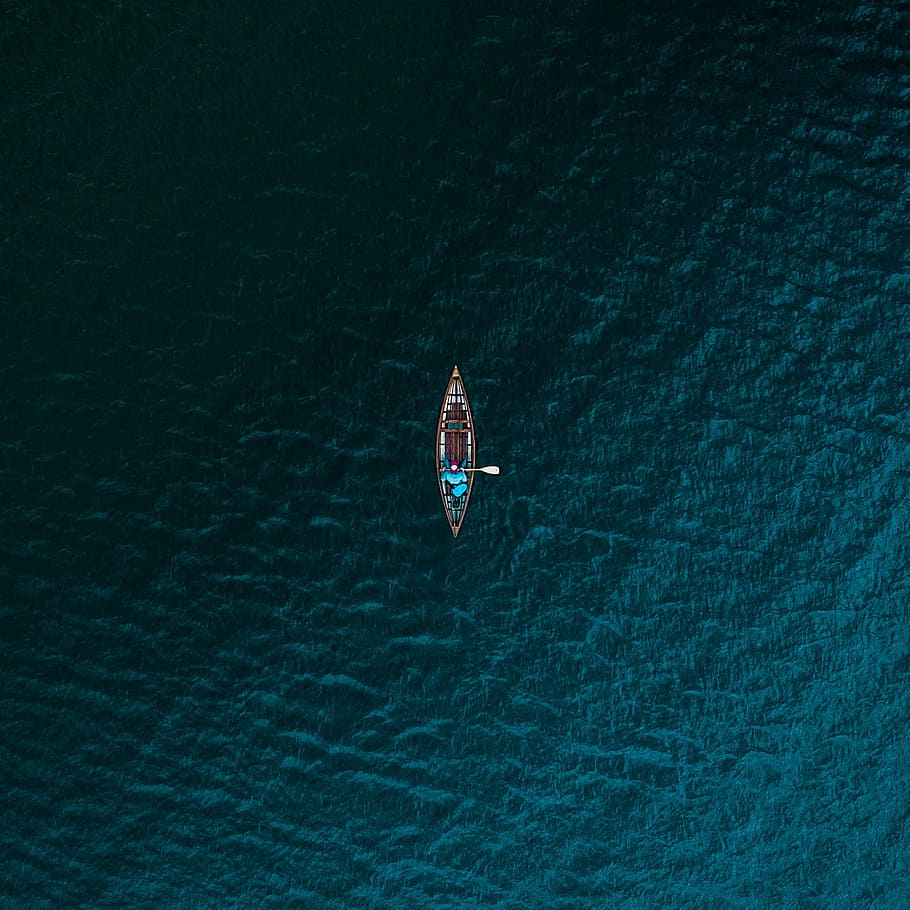 aerial photography of person riding boat on body of water, Centered