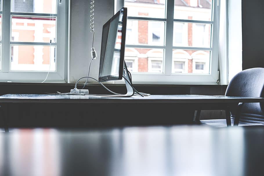 tilt shift lens photography of silver iMac on table, black flat screen TV HD wallpaper