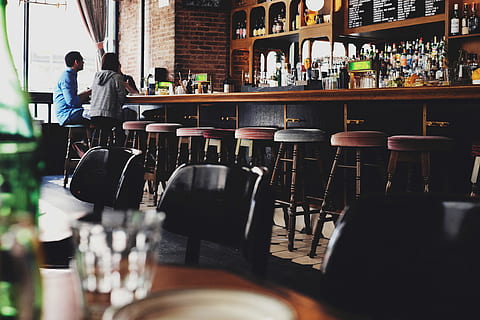 two person sitting on bar stool chair in front of bar front desk, two people sitting on brown wooden chairs HD wallpaper