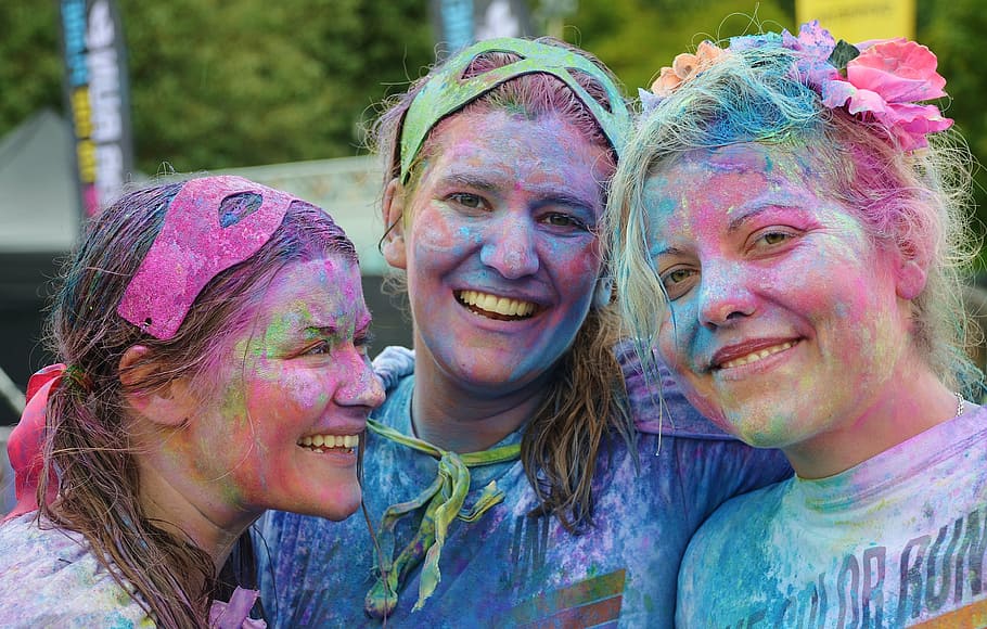 three woman enjoying Holi event during day time, girls, colorful