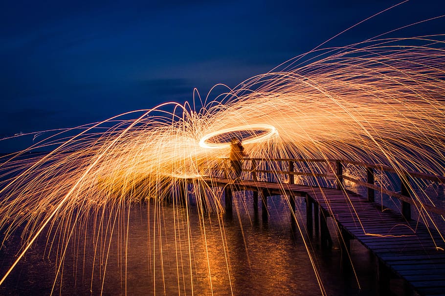 steel wool photography of person standing on sea dock, steel wire photography HD wallpaper
