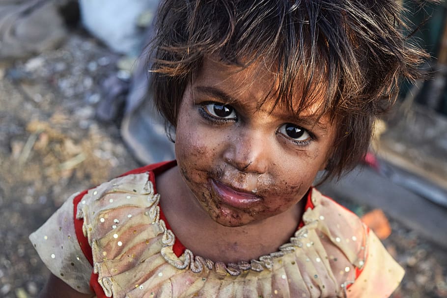 close up photo of girl wearing brown shirt with face covered with dirt