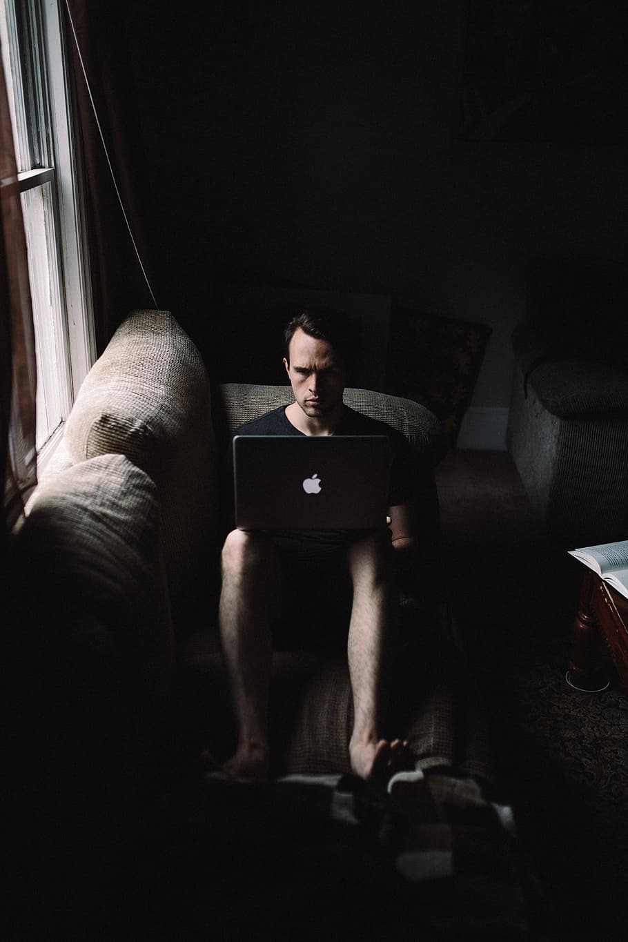 man seating on sofa using MacBook beside window, man sitting on grey couch using MacBook HD wallpaper