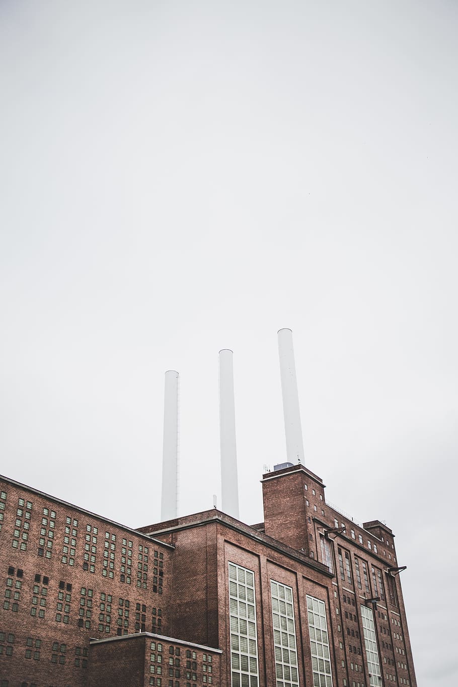brown factory under clear sky, low angle photography of brown building HD wallpaper
