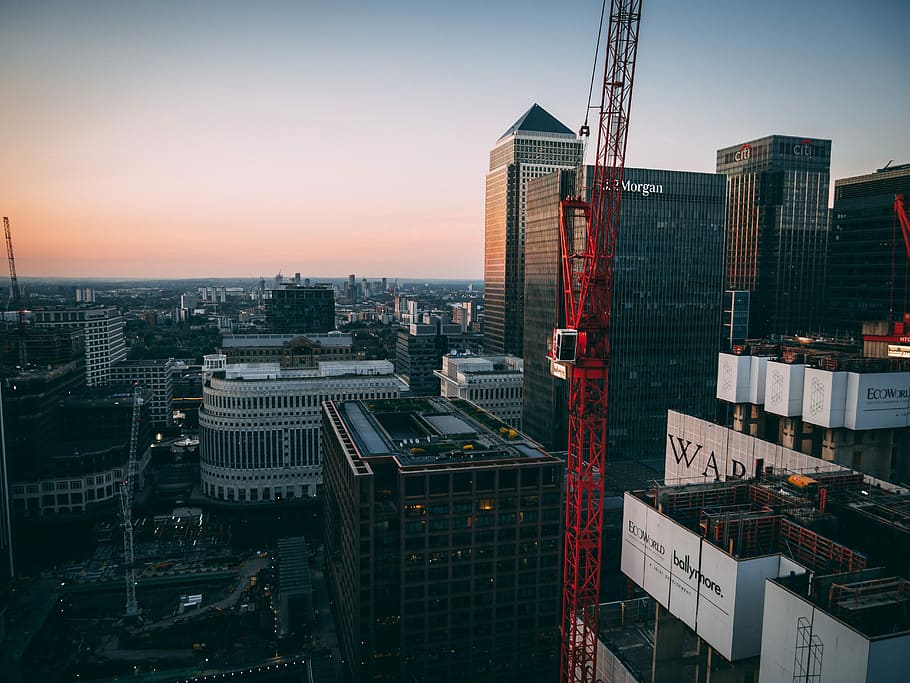 red tower crane between buildings, aerial photography of city buildings and tower crane