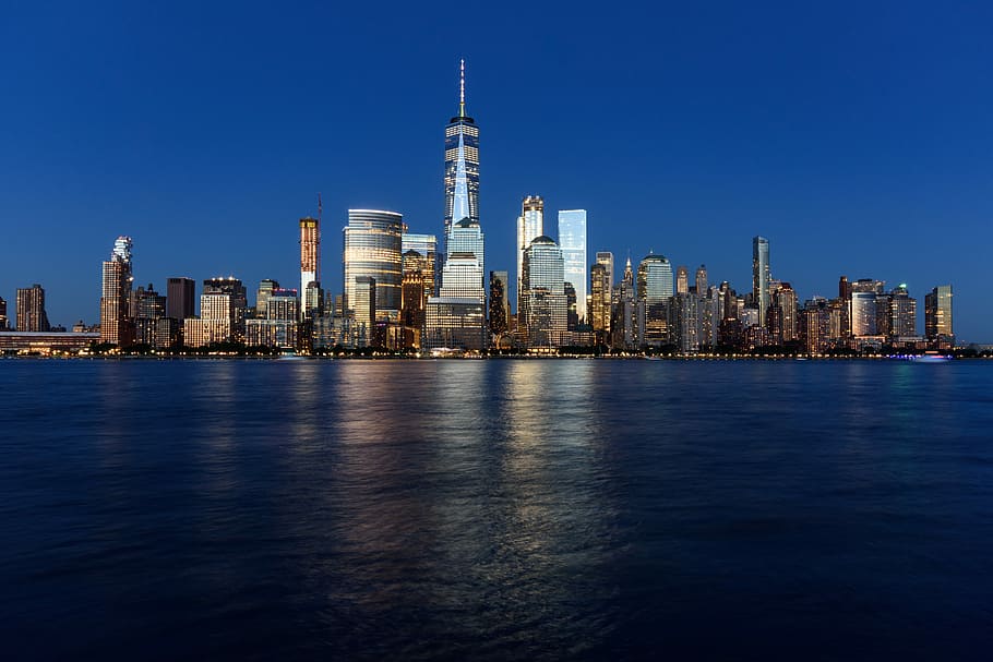 landscape shot of buildings surrounded body of water, lighted building at night near body of water HD wallpaper