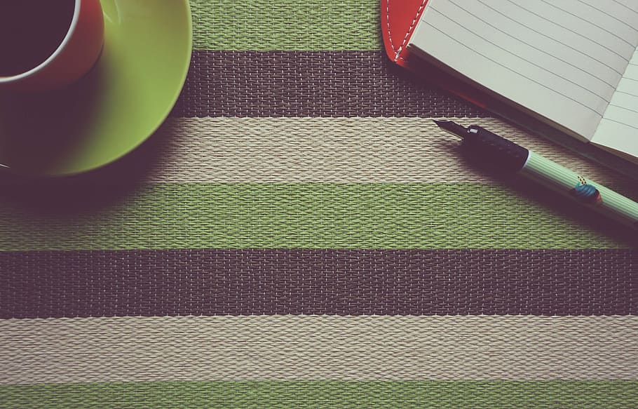 green ceramic teacup with saucer beside white notebook with pen HD wallpaper