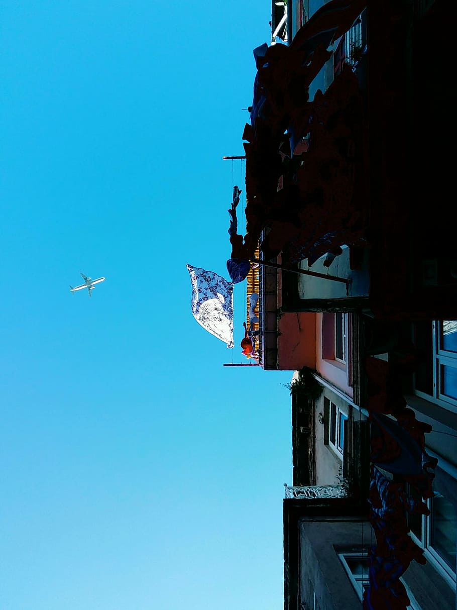 Through the sky, low-angle of building and plane flying, blue HD wallpaper