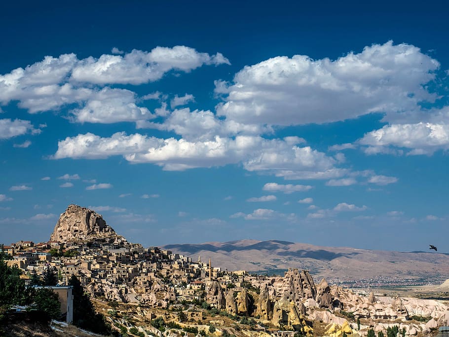 Landscape with houses in stones under sky and clouds in Cappadocia, Turkey HD wallpaper