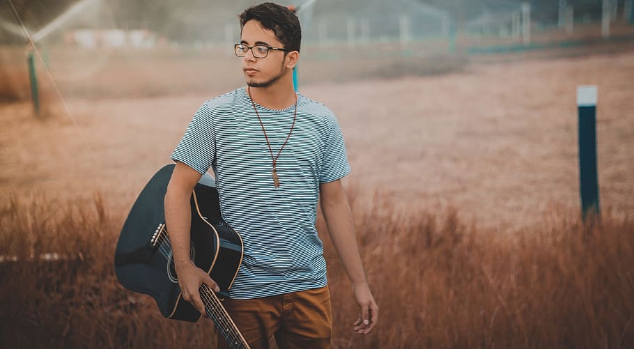man holding cutwaya acoustic guitar, man holding guitar looking towards left HD wallpaper