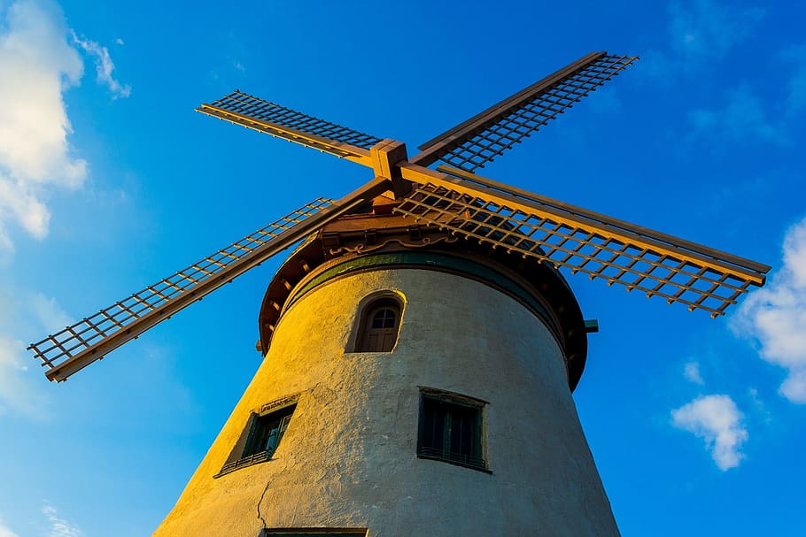 gray and brown concrete building during blue sky, windmill HD wallpaper