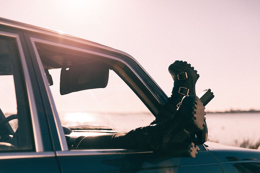 person sitting inside car, person wearing black boots lying inside vehicle HD wallpaper