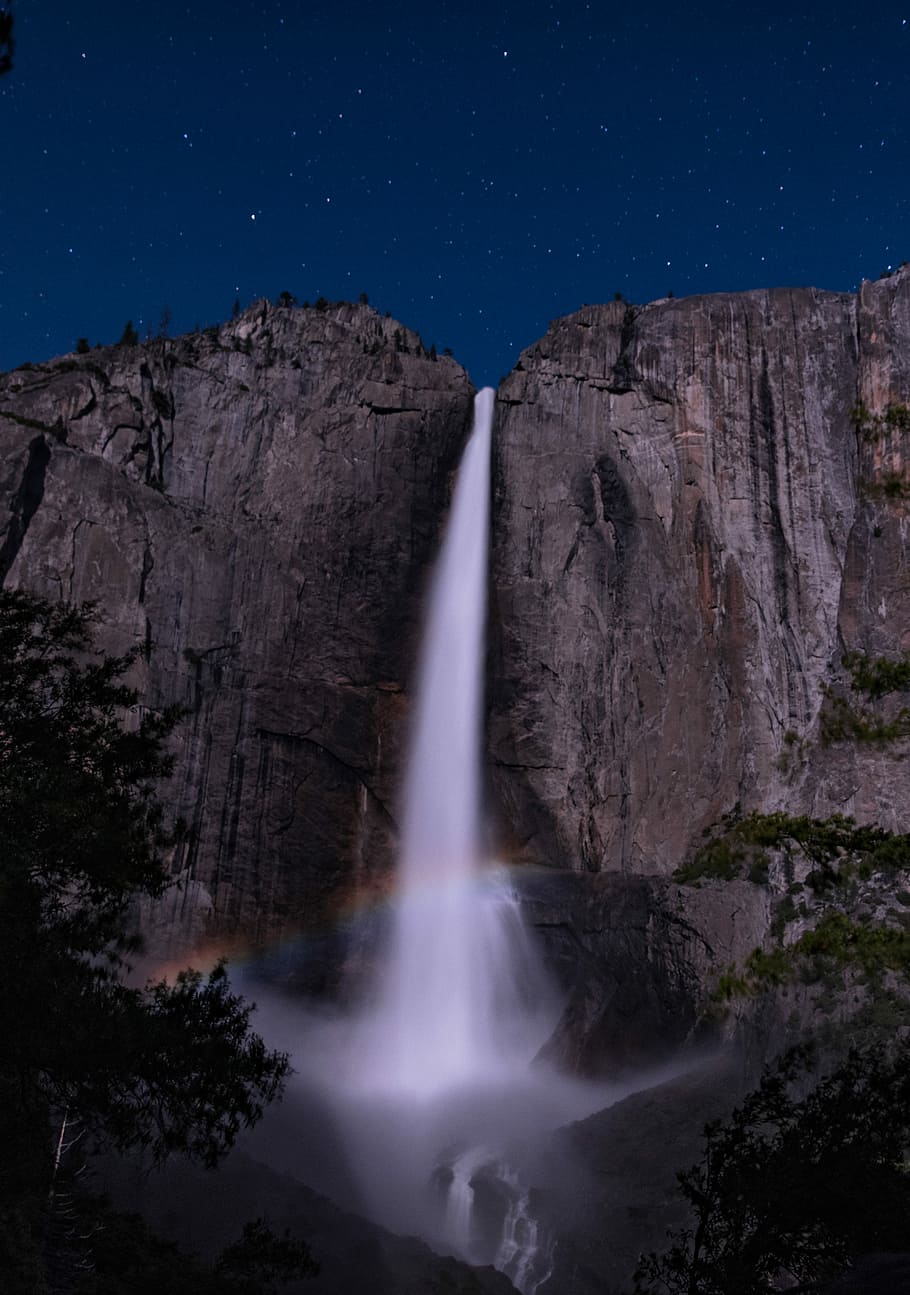 rainbow in front of waterfalls at night time, low angle photography of waterfalls at night HD wallpaper