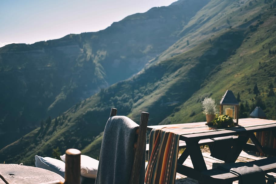 brown picnic table near mountain, brown wooden picnic table with tabletop plant fronting green mountain HD wallpaper