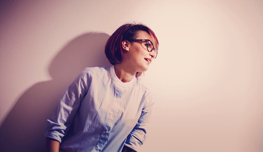 woman wearing black-framed eyeglasses and blue button-up long sleeved shirt