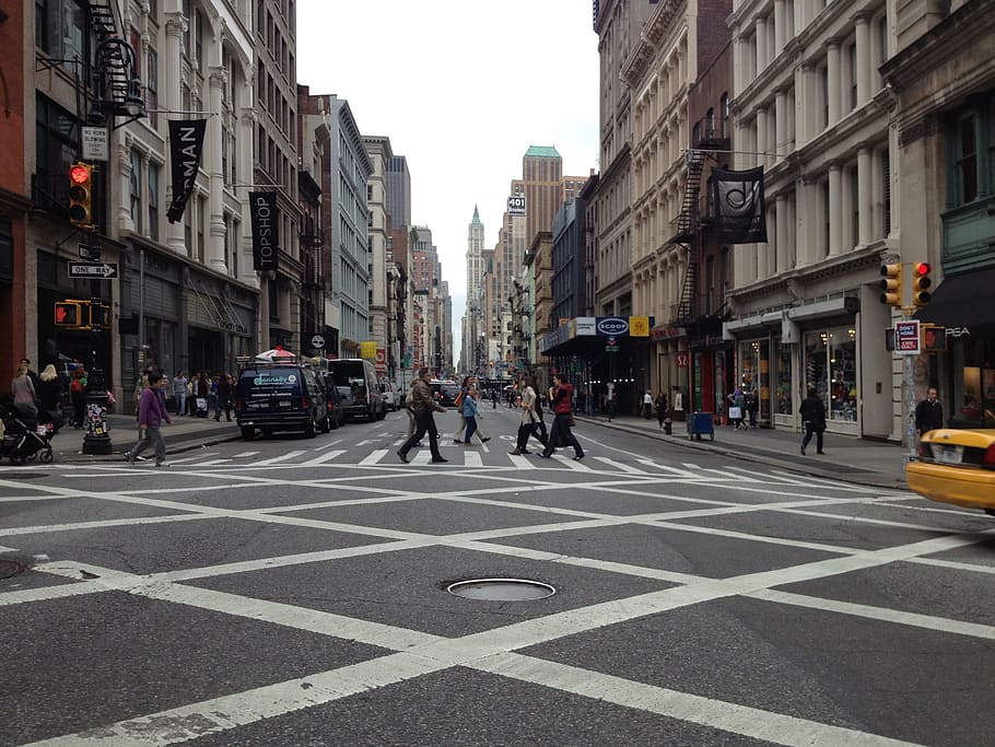 people crossing at the street between tall buildings during daytime HD wallpaper
