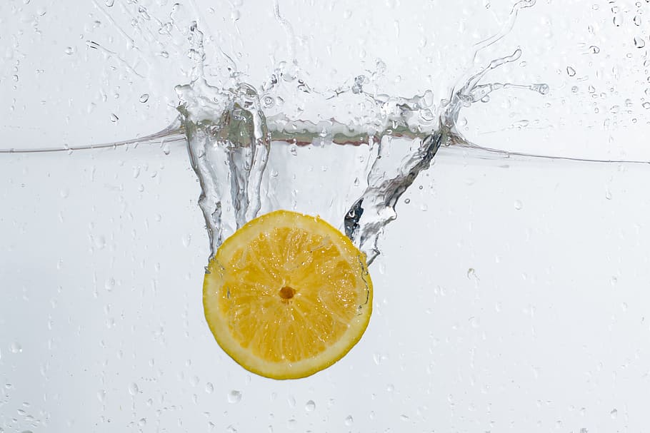 underwater photo of sliced lemon drop in water, lemonade, fruit