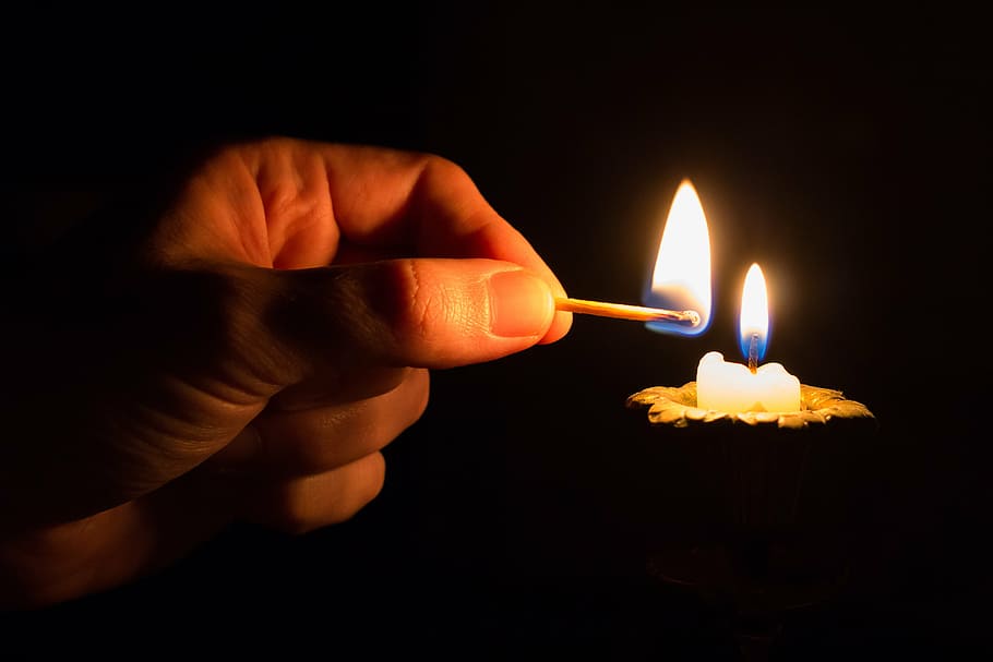 person lighted candle using match stick, energy, of technology