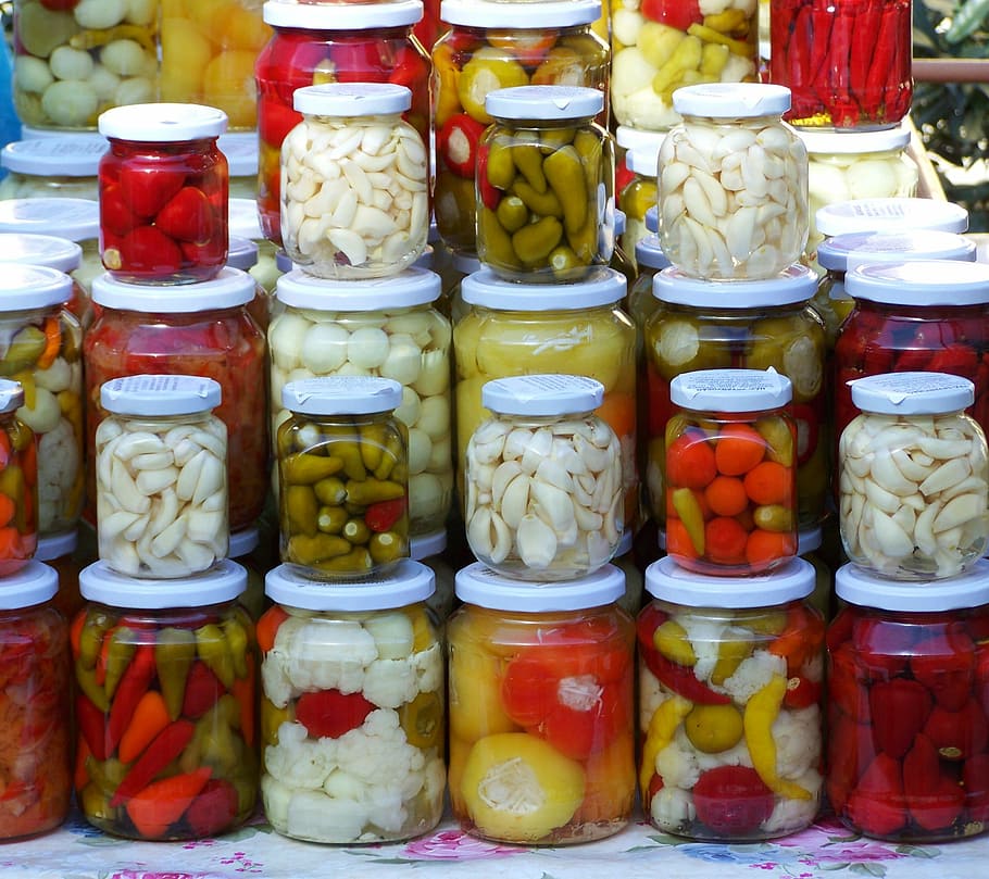 assorted infused vinegar bottles, pickled vegetables, pickles