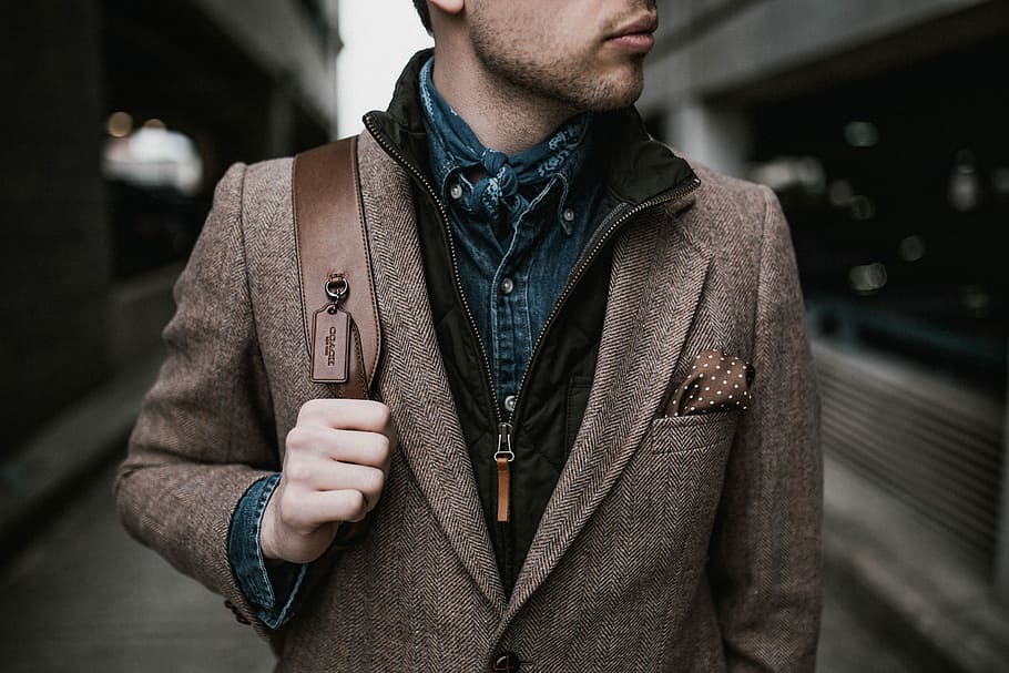 man in brown suit jacket carrying brown backpack, man standing near gray wall, HD wallpaper