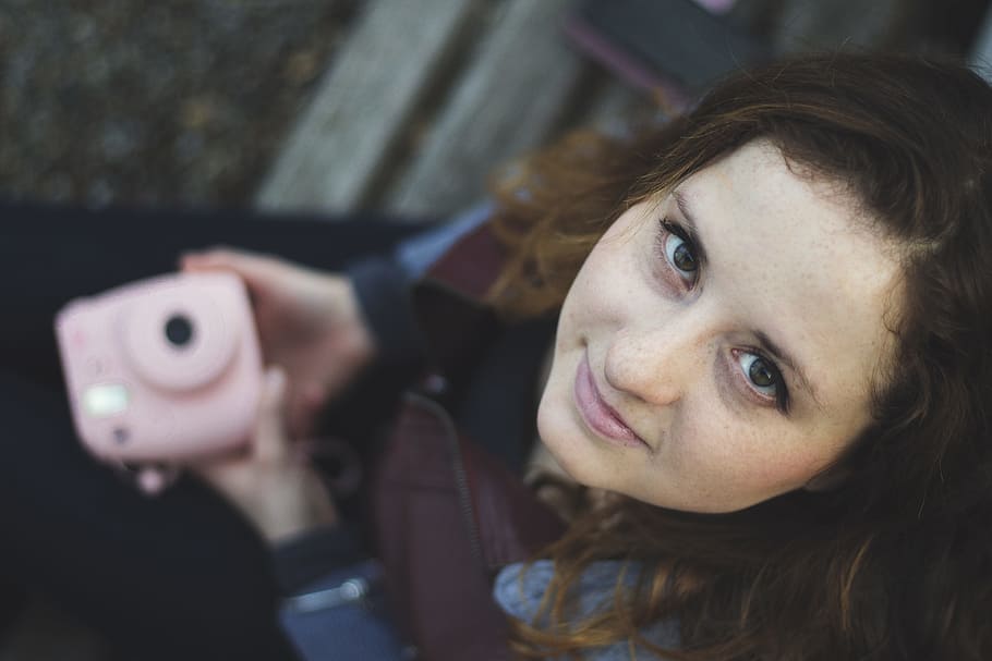 woman wearing brown leather jacket holding pink camera, woman holding Instax camera HD wallpaper