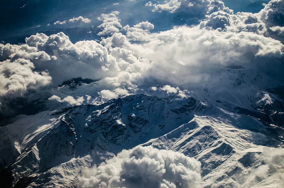 bird's eye view of mountain under clouds, aerial photo of snow-capped mountain under thick white clouds HD wallpaper