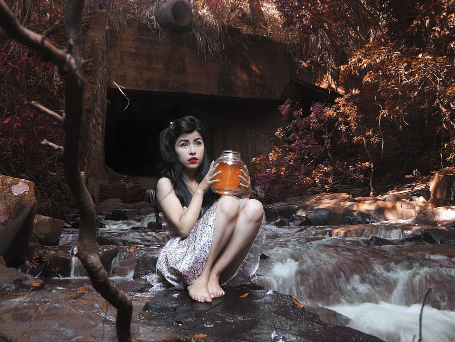 sitting woman holding glass jar on black stone with crushing water HD wallpaper