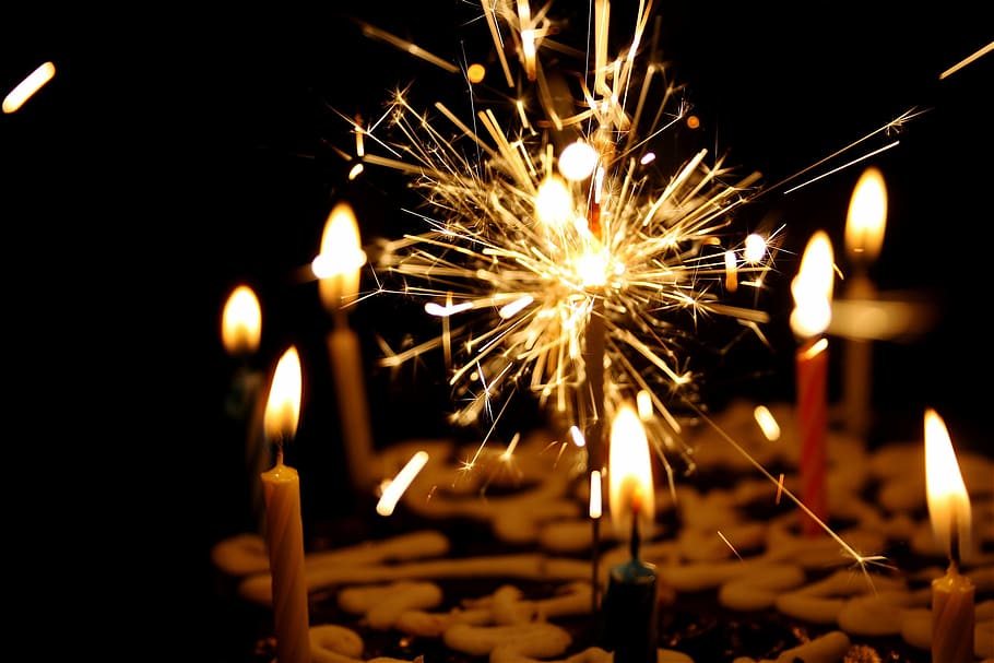 close up photography of sparkler beside candles, lighted candles and sparkling candle HD wallpaper