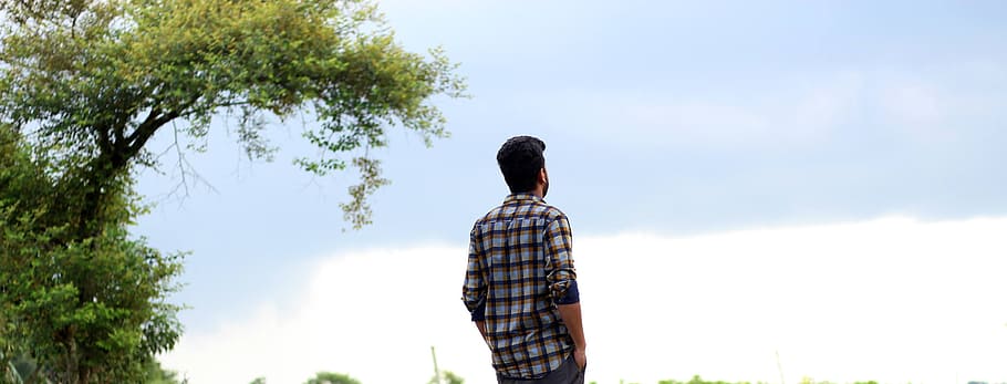 man standing near tree, alone boy, sad, lonely, young, unhappy