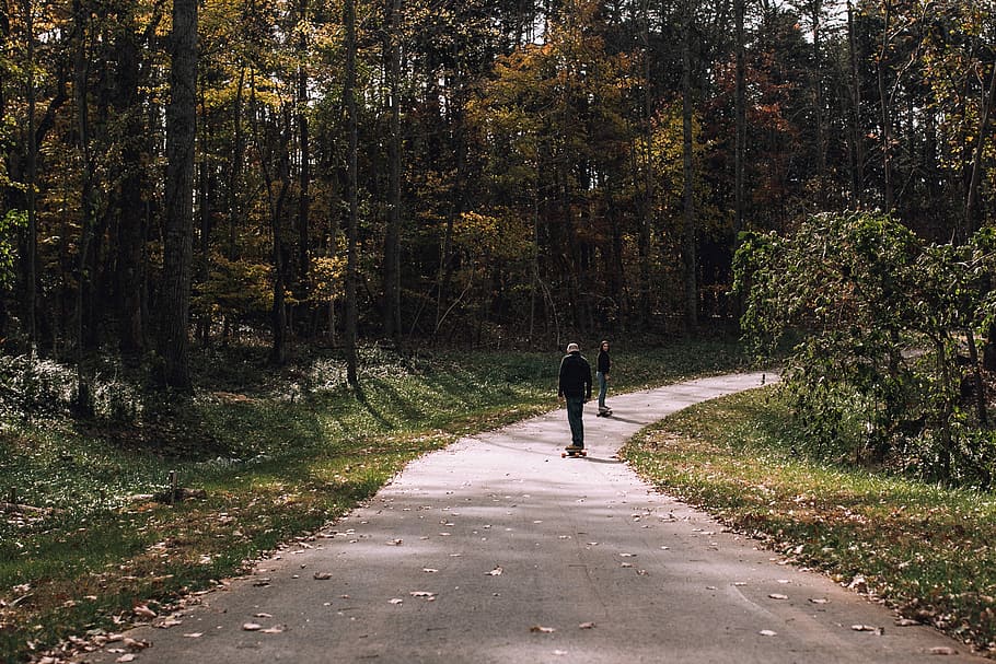 two person looking at each other on pavement road, man skateboarding on gray road HD wallpaper