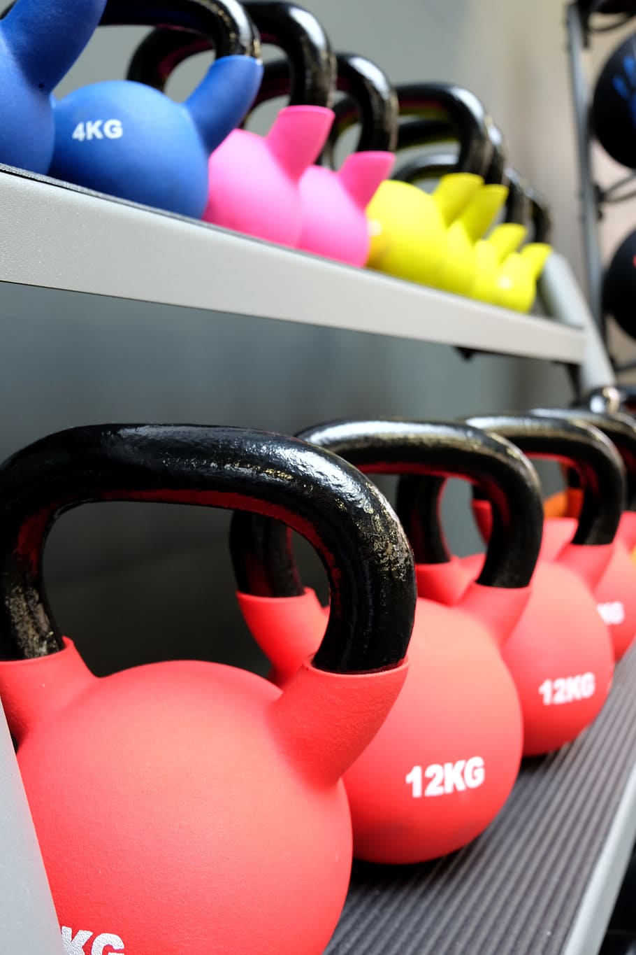 shallow focus photography of kettlebells on top of rack, gym