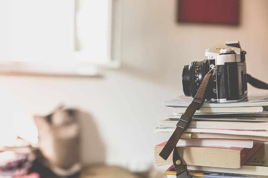 black film camera on top of piled books inside well lighted room, photo of black and silver disposable camera on top of books HD wallpaper