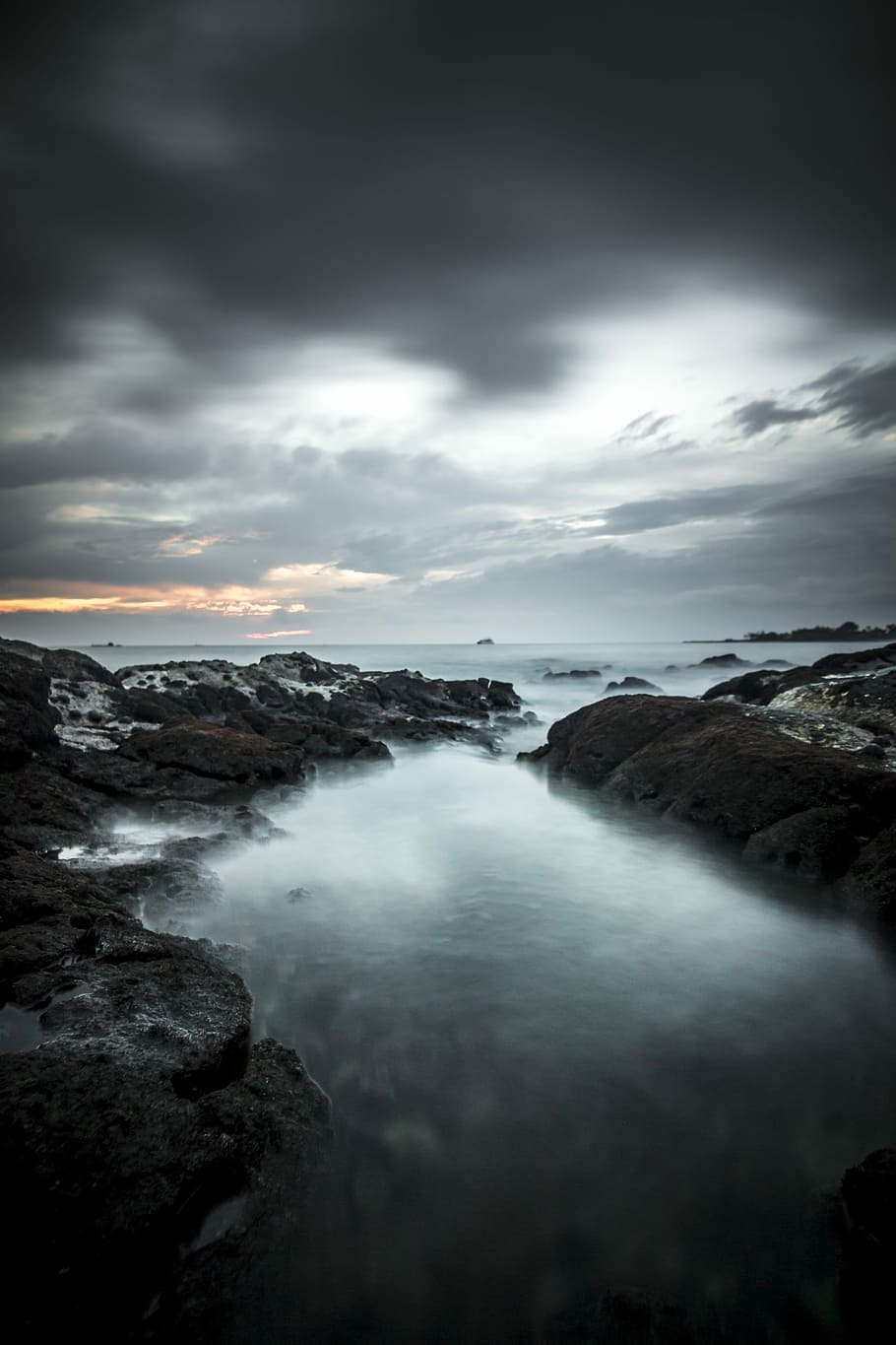 sea under gray sky, body of water with rock under cloudy sky HD wallpaper