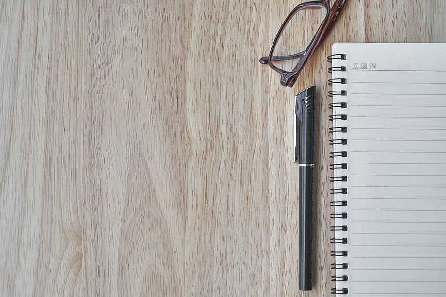 pen beside notebook and eyeglass on wooden surface, eyewear, to write
