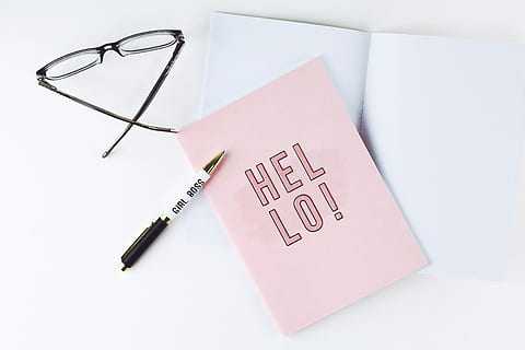 black ballpoint pen beside pink paper with hello written, pen, eyeglasses, and pink paper on white desk HD wallpaper