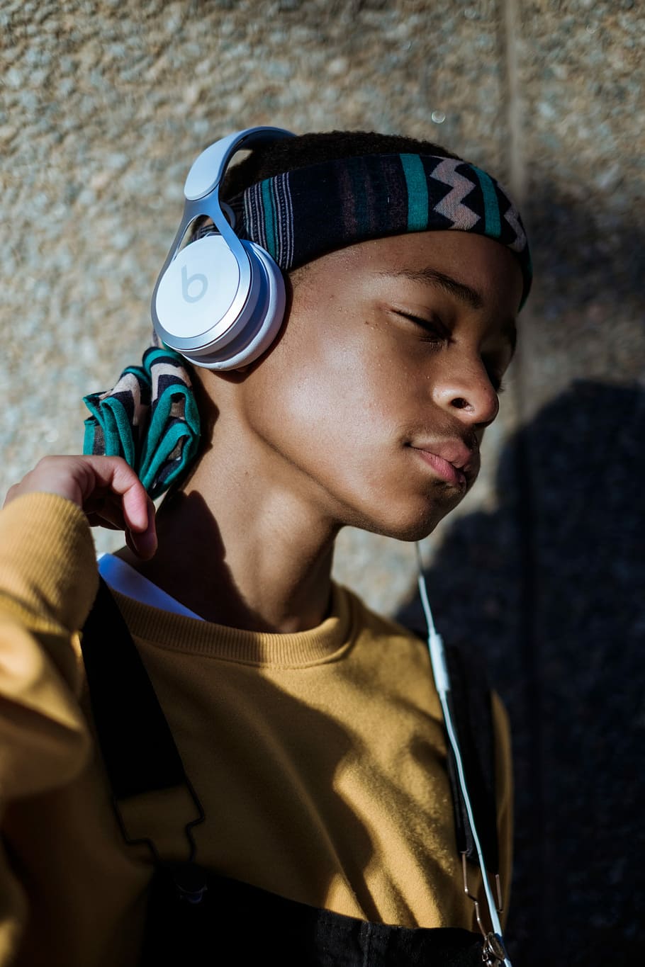 boy listening headphones, boy wearing yellow sweater listening to music